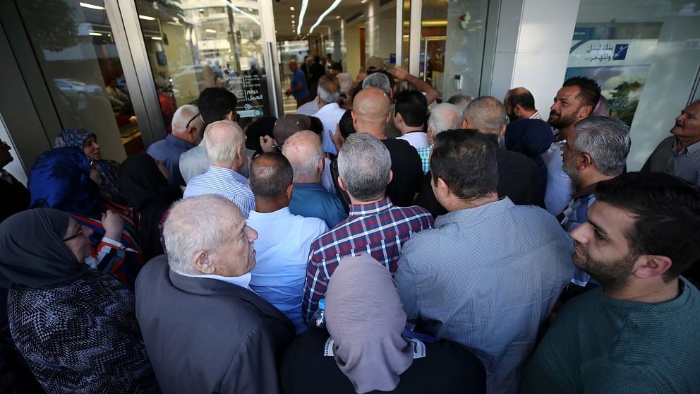 Människor som på fredagen köade utanför en bank i staden Sidon. Banker har hållit stängt under de senaste två veckorna som en följd utav demonstrationerna.