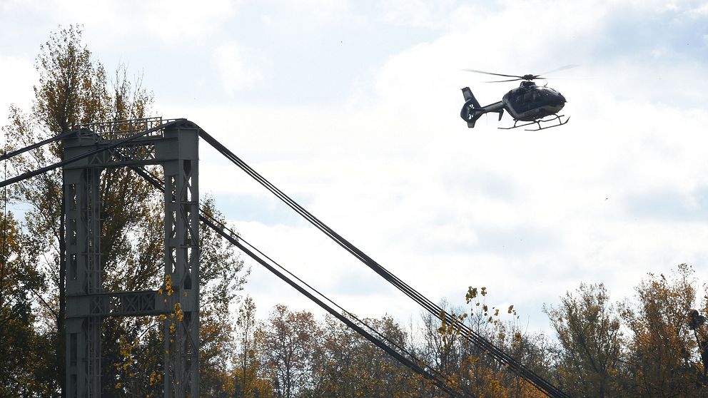 En helikopter flyger över en hängbro i en räddningsinsats.
