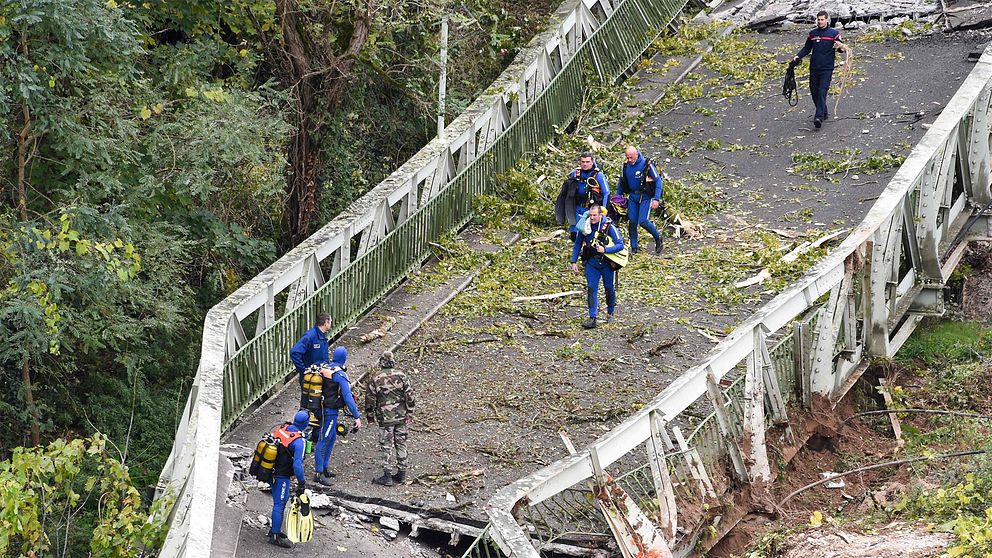 Räddningsarbetare går på en bro som har rasat.