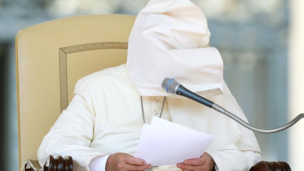 Pope Francis matle blown by the wind covers his face as he leads the weekly general audience at St Peter's square on August 27, 2014 in Vatican City.