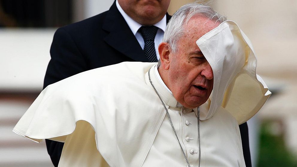 A gust of wind blows Pope Francis' mantle as he leaves at the end of his weekly audience in Saint Peter's Square at the Vatican November 5, 2014.