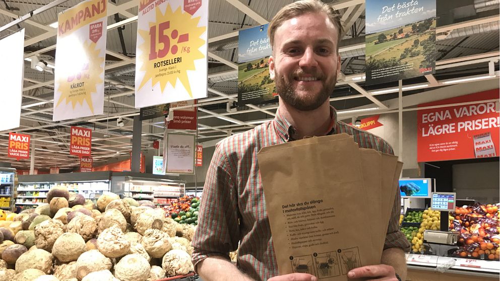 Joel Lundholm, avldeningschef över frukt och grönt i en Ica maxi-butik håller upp matavfallspåsar.