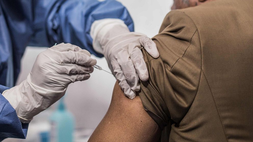 Sjukvårdare ger ebolaspruta till en man i Kongo.
