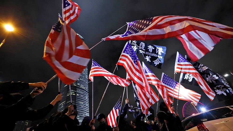 Demonstranter viftar med amerikanska flaggor under en demonstration i Hongkong.
