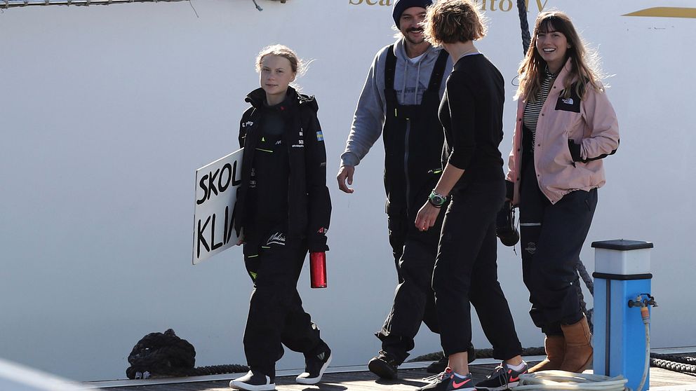 Greta Thunberg kliver i land i Lissabon, Portugal, med ”skolstrejk för klimatet”-skylten i sin hand.
