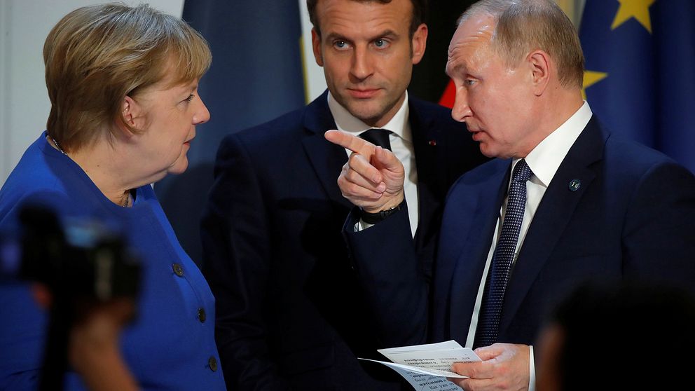 Tysklands förbundskansler Angela Merkel i samspråk med Rysslands president Vladimir Putin under en presskonferens i Paris i måndags. I bakgrunden den franske presidenten Emmanuel Macron