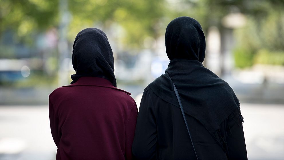 Två kvinnor i hijab fotograferade bakifrån.