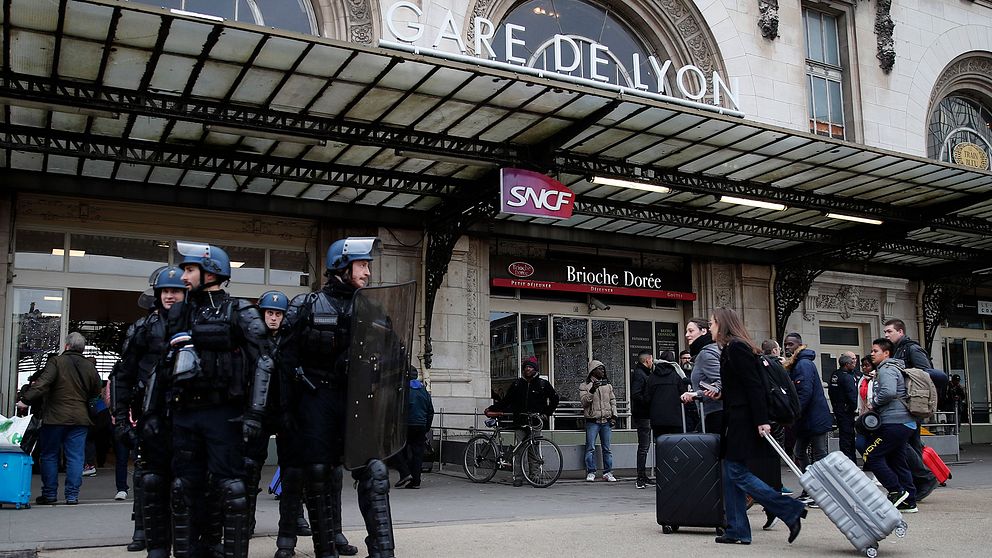Kravallpolis bevakar järnvägsstationen Gare de Lyon i Paris när järnvägsarbetare demonstrerar mot höjd pensionsålder.