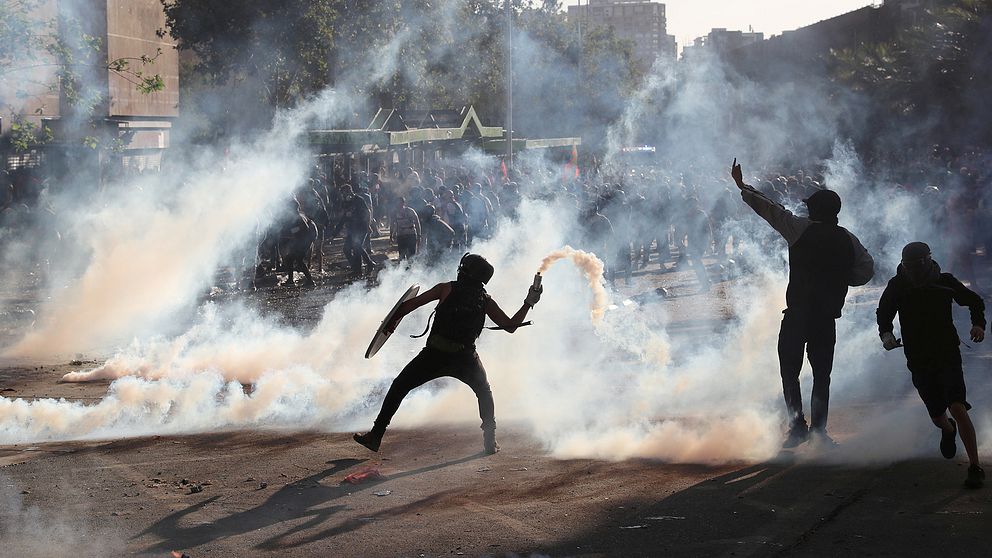 En demonstrant i Chile kastar tårgas.