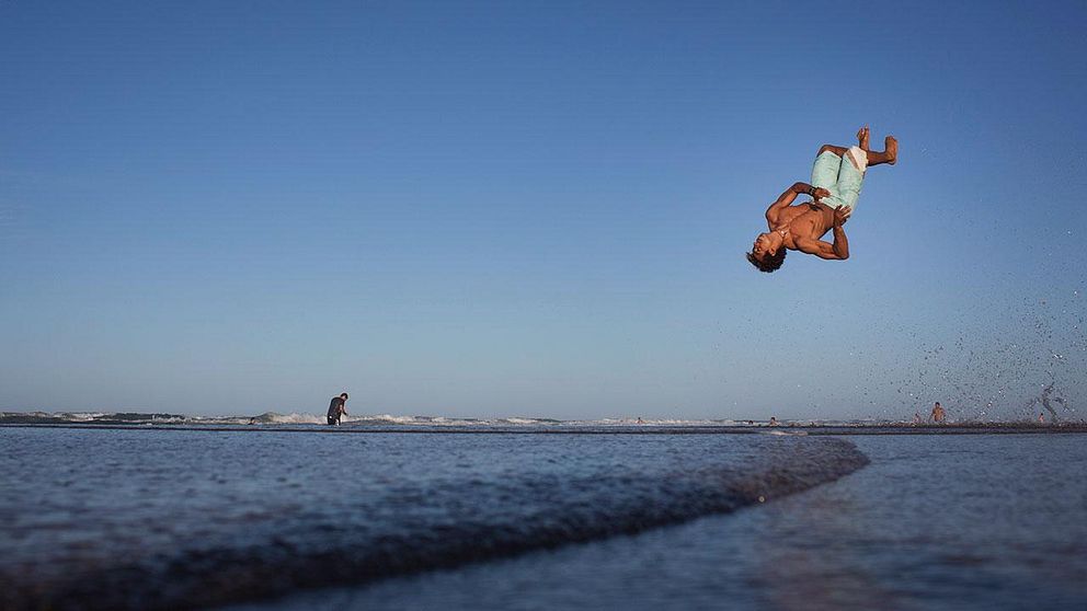 Man tränar capoeira på strand i Brasilien.