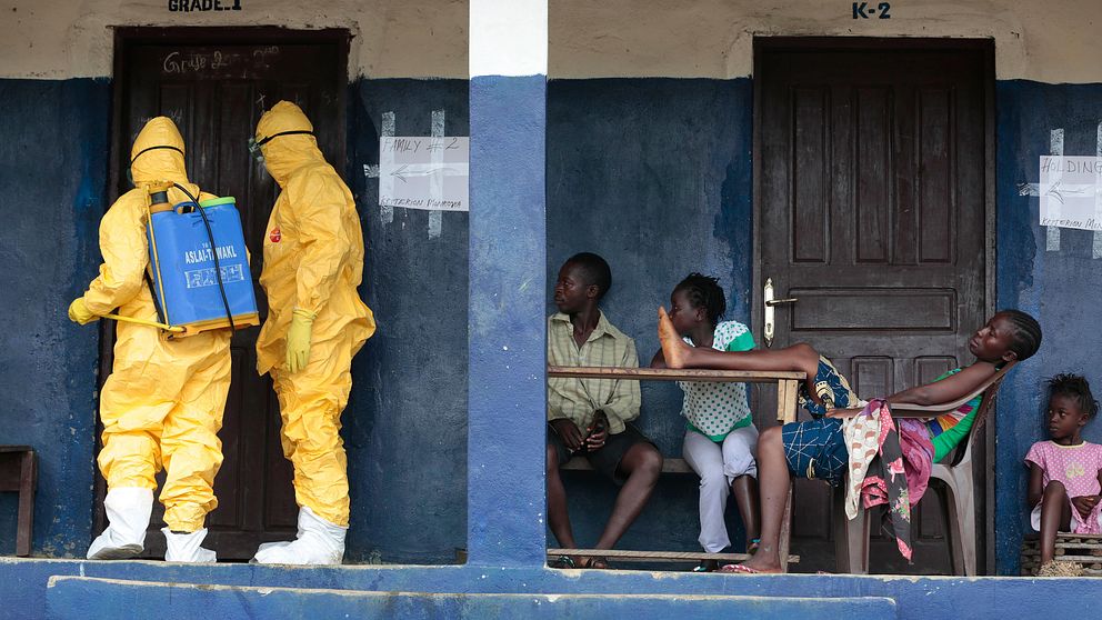 Arkivbild från byn Freeman Reserve 5 mil norr om Liberias huvudstad Monrovia. Sjukvårdrare descinficerar ett rum samtidigt som de hämtar sex personer som  misstänks bära på smittan och som satts i karantän.
