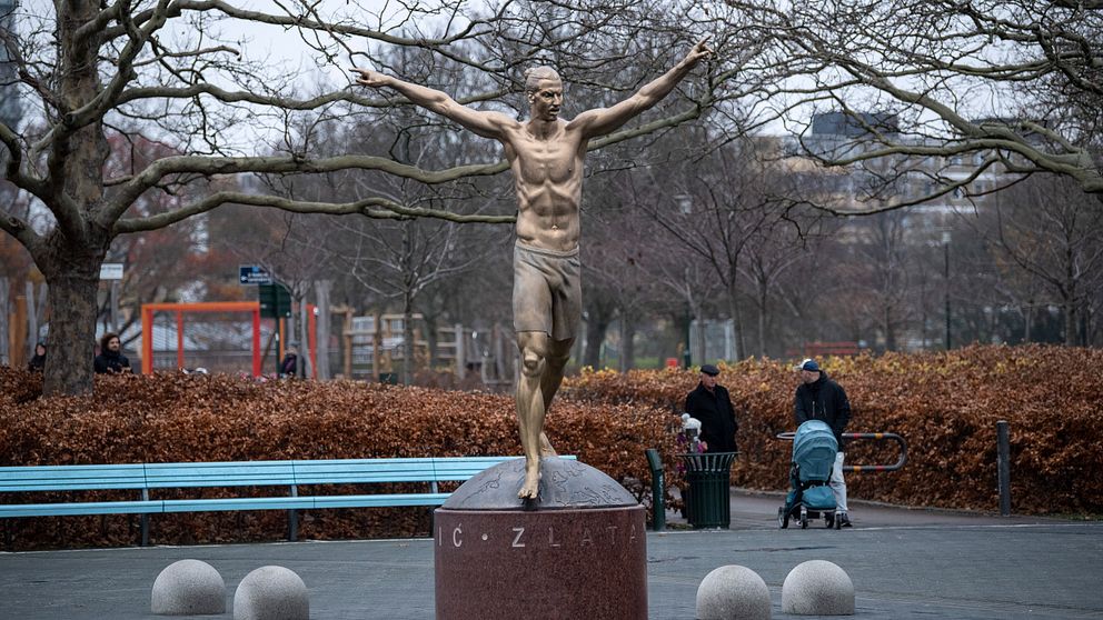 Bronsstaty av fotbollsspelaren Zlatan Ibrahimovic som sträcker ut armarna på var sida i en segergest.