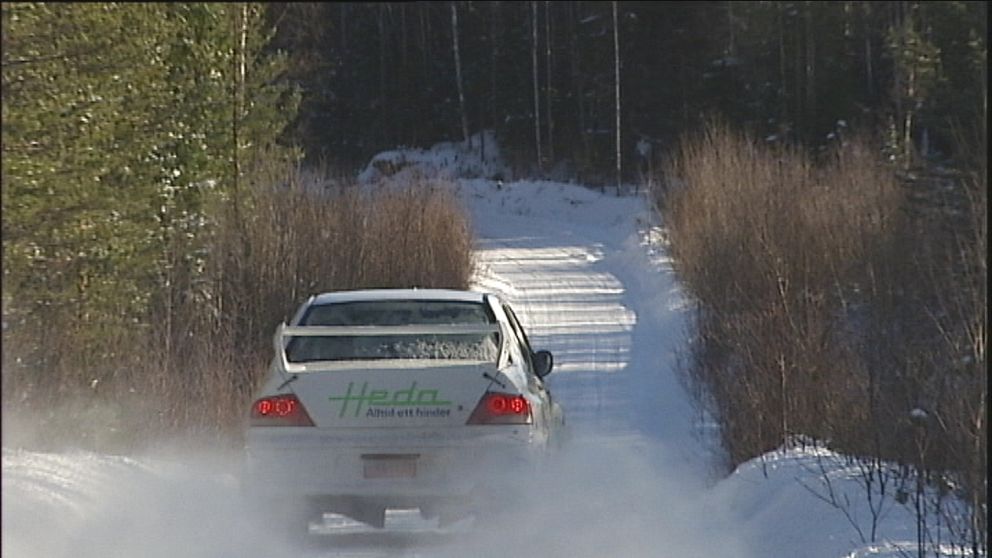 Rallybil på väg på en vintrig skogsväg