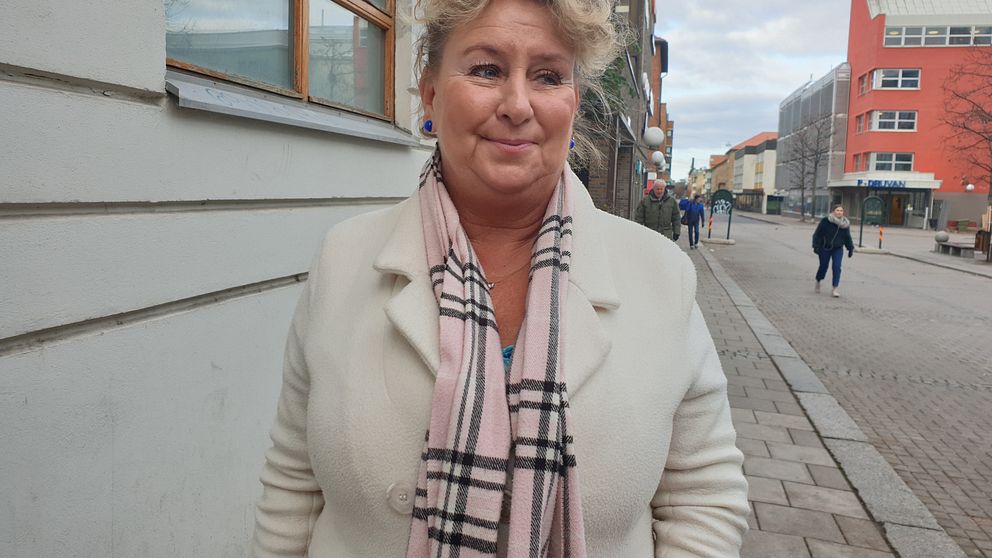 Anette Dunå står på en gata i Linköping klädd i vit kappa. Hon ser nöjd ut.