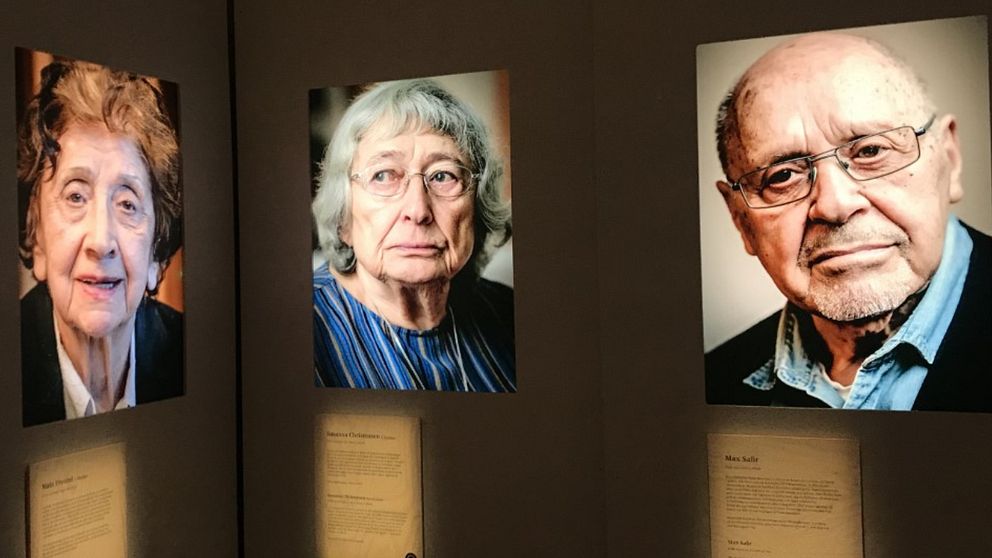 Tre porträttfotografier av äldre personer på en vägg.