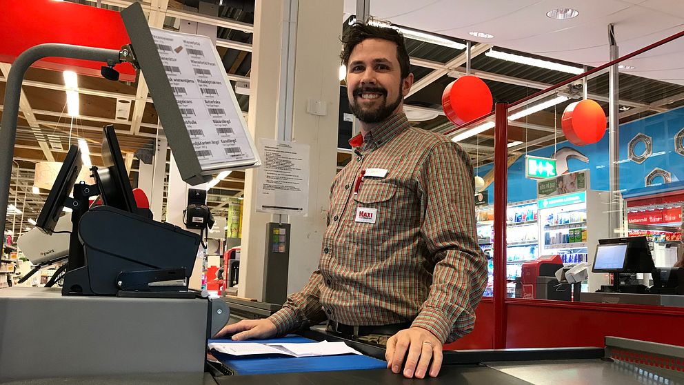 Porträttbild i form av halvbild tagen på Jens Selahn på Ica Maxi Hudiksvall som står bakom en kassa.