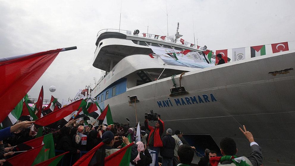 In this Sunday, Dec. 26, 2010 file photo, people holding Turkish and Palestinian flags cheer as the Mavi Marmara ship, the lead boat of a flotilla headed to the Gaza Strip which was stormed by Israeli naval commandos in a predawn confrontation in the Mediterranean on May 31, 2010, arrives back in Istanbul, Turkey. Turkey said Friday Sept. 2, 2011 it was expelling the Israeli ambassador and cutting military ties with Israel over the last year's deadly raid on a Gaza-bound aid flotilla, further souring the key Mideast relationship between Turkey and Israel.(AP Photo/Burhan Ozbilici, File)