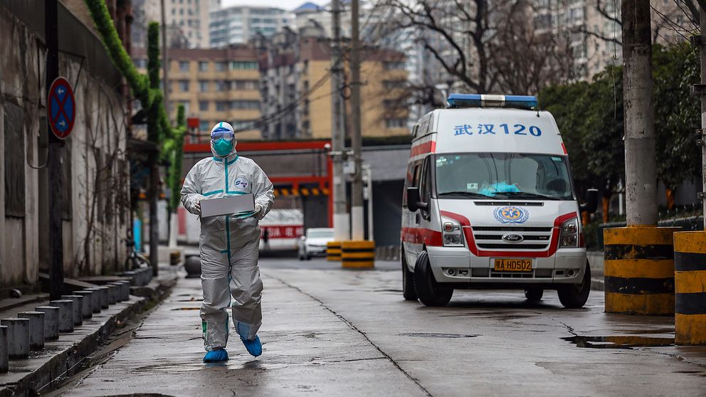 En skyddsklädd ambulansförare utanför sjukhuset i Wuhan, ett av de områden där flest fall av coronaviruset rapporterats