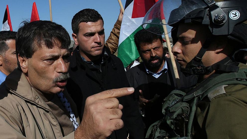 Ziad Abu Ein (t.v.) diskuterar med en israelisk soldat just före gripandet