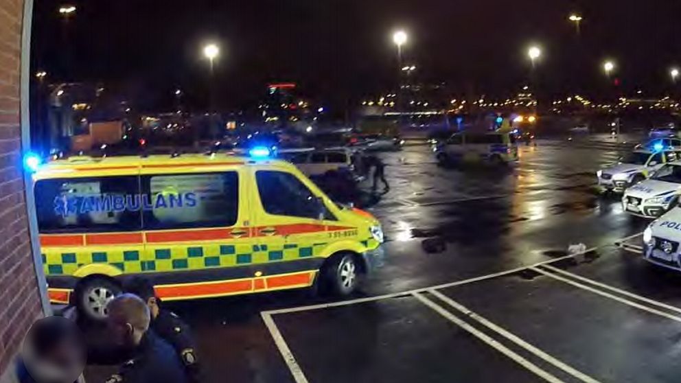 Poliser och ambulans på parkering.