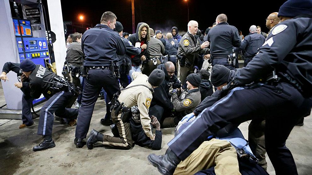 Polis stoppar de upprörda folkmassorna som samlats för att demonstrera mot dödskjutningen i Berkeley.