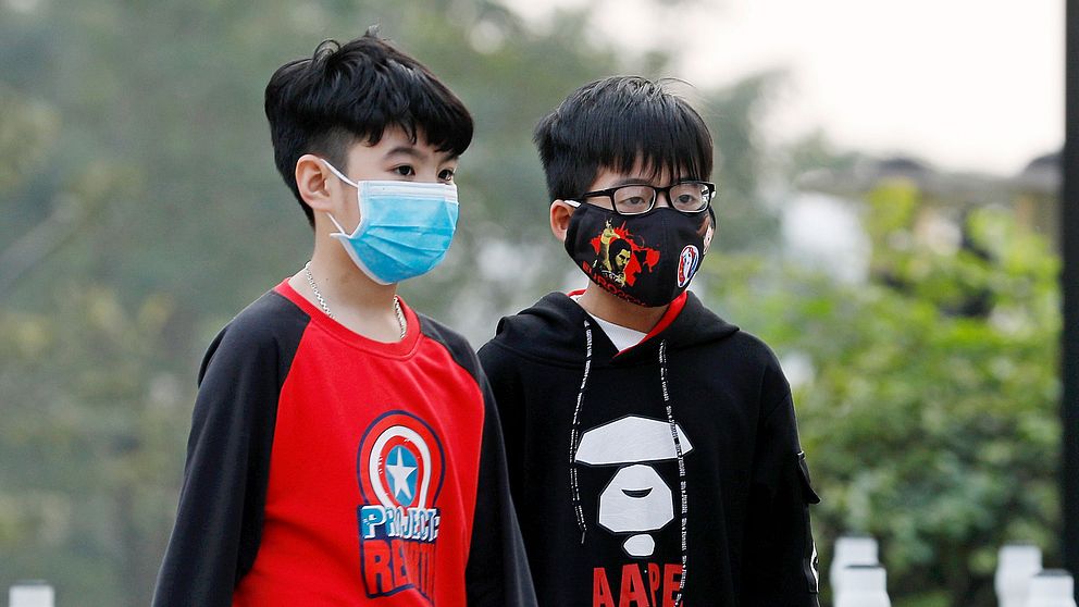 Barn med ansiktsmasker i Hanoi i Vietnam
