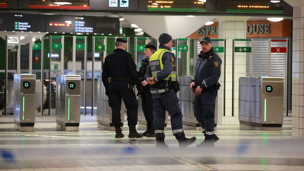 Poliser står innanför avspärrningsband