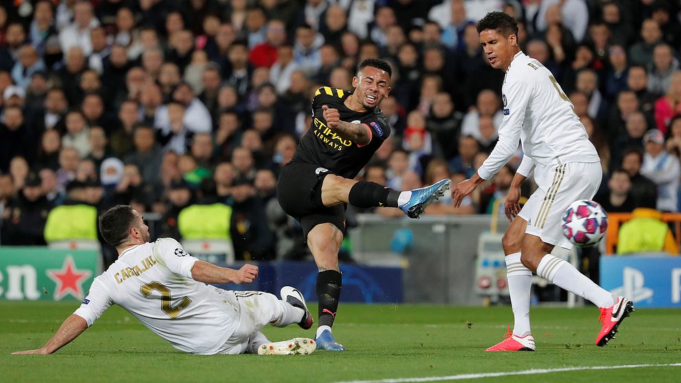 Manchester Citys Gabriel Jesus avlossar ett skott och Real Madrids Dani Carvajal och Raphael Varane försöker blockera.