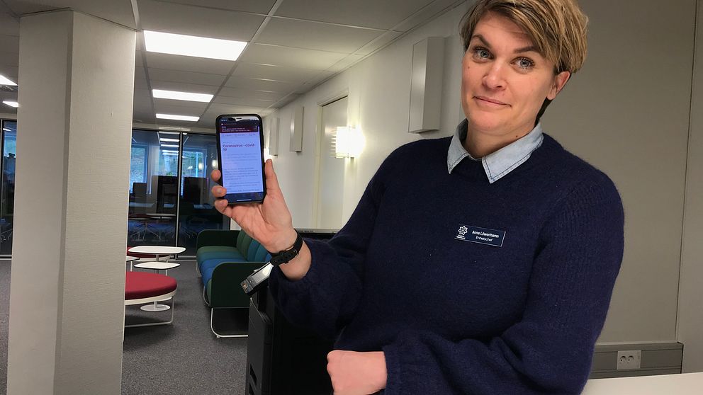 Anna Löwenhamn håller upp en mobiltelefon.