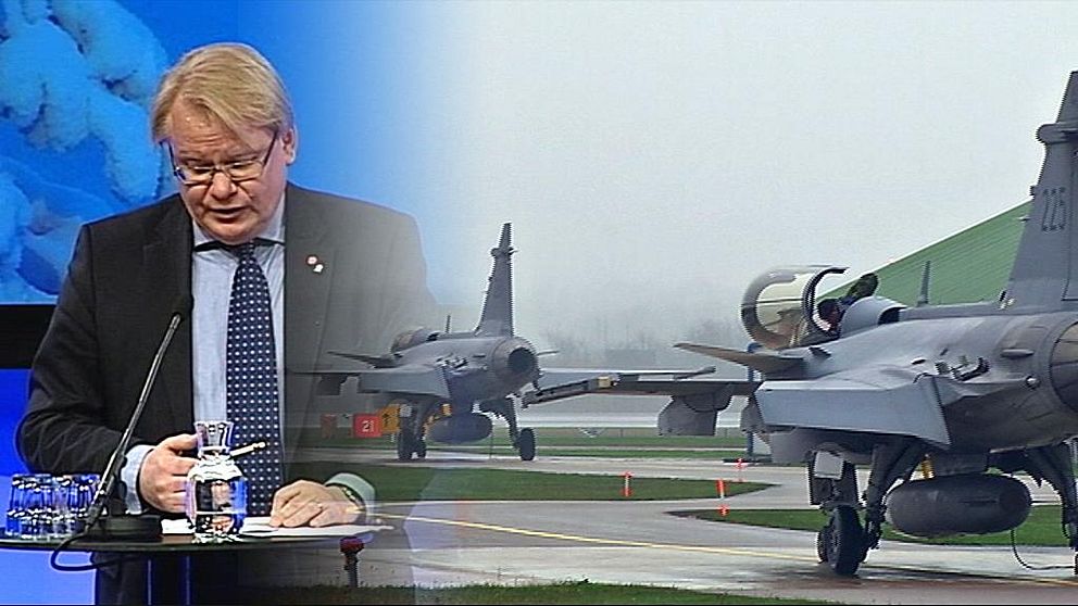 Försvarsminister Peter Hultqvist inklippt bredvid ett Jasflygplan.