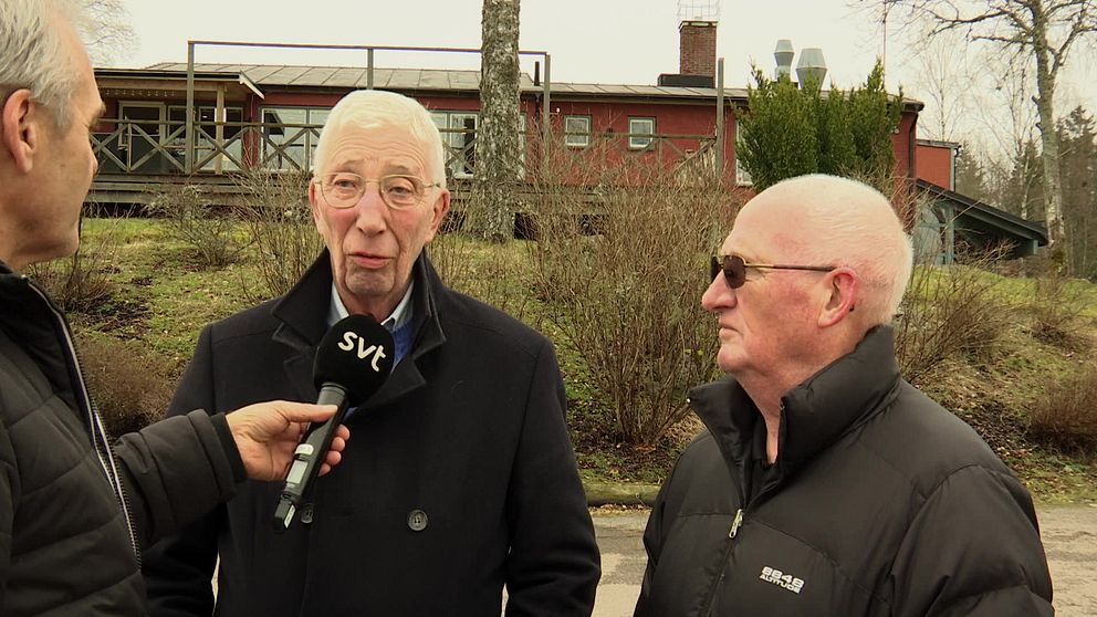 Två äldre män blir intervjuade utomhus