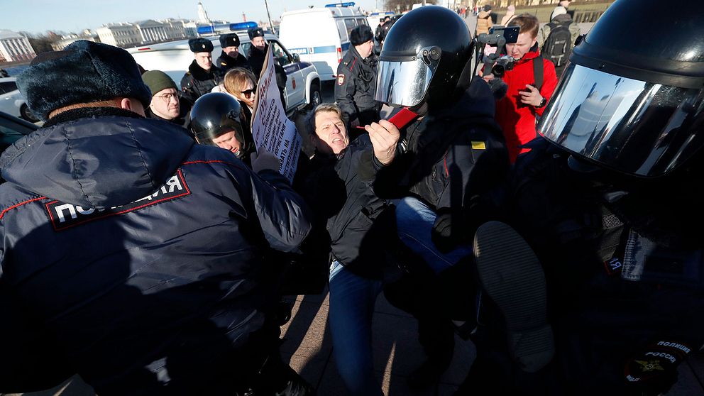 Rysk kravallpolis griper demonstrant utanför författningsdomstolen i Sankt Petersburg den 15 mars 2020.