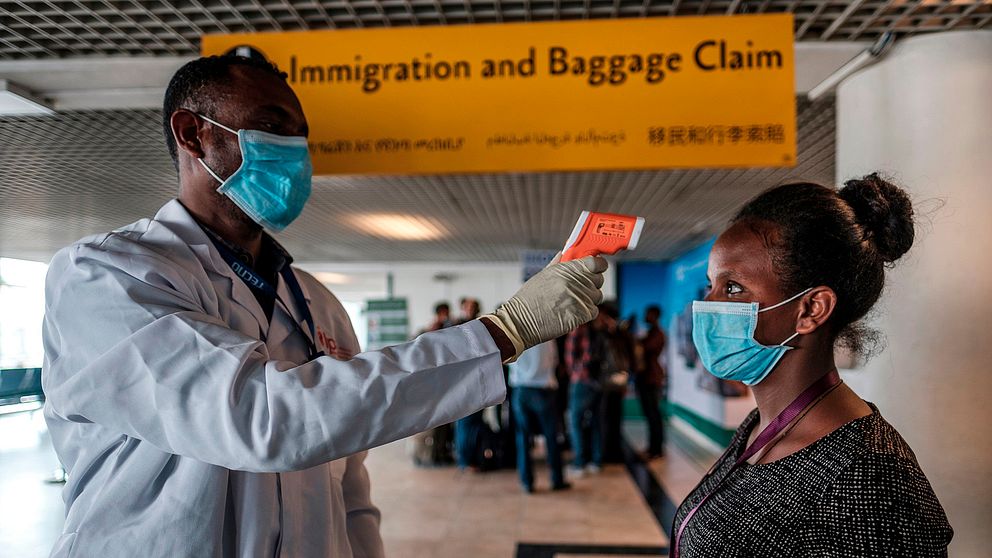 En arbetare från den etiopiska hälsomyndigheten tar tempen på en arbetare på den internationella flygplatsen i huvudstaden Addis Ababa.