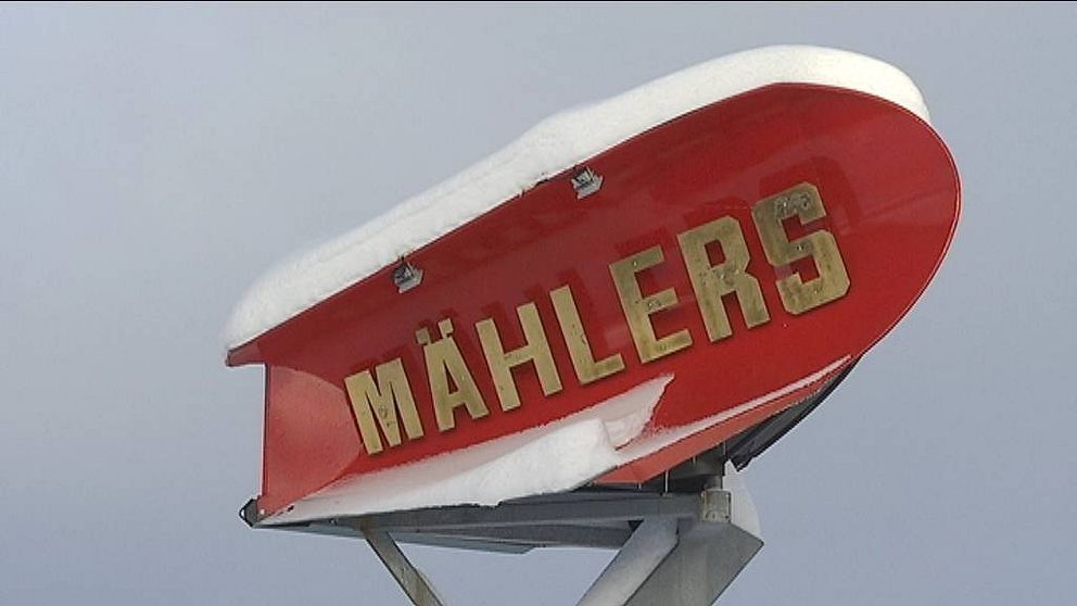 Röd snöplog på en pelare med texten Mählers i guld.