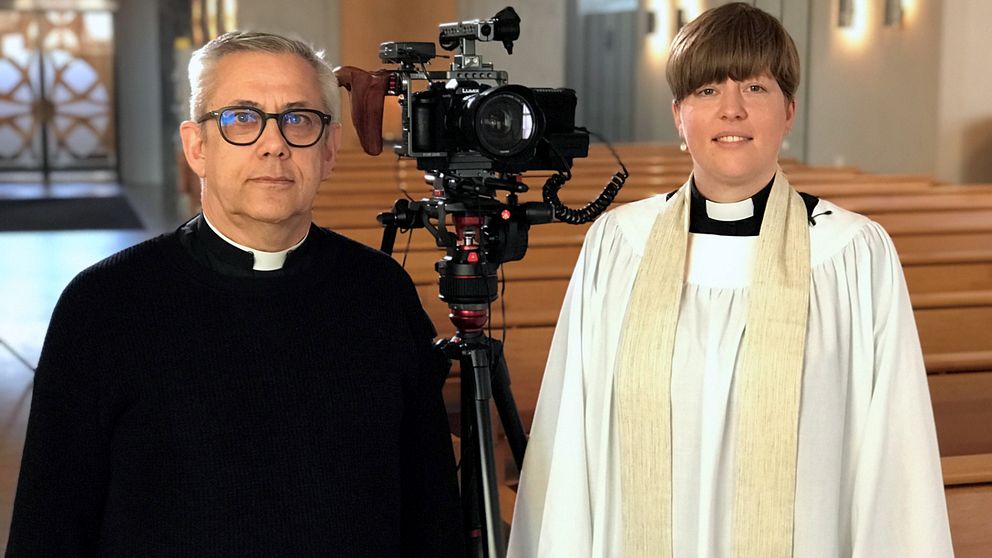 Martin Eriksson, kyrkoherde, och Ulrika Morén, präst, vid en kamera i S:ta Helena kyrka i Skövde.