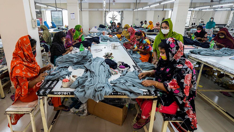 Arbetare i en klädfabrik i Asulia, Bangladesh. Bilden är tagen i samband med att regeringens karantänsåtgärder mot coronaviruset infördes.