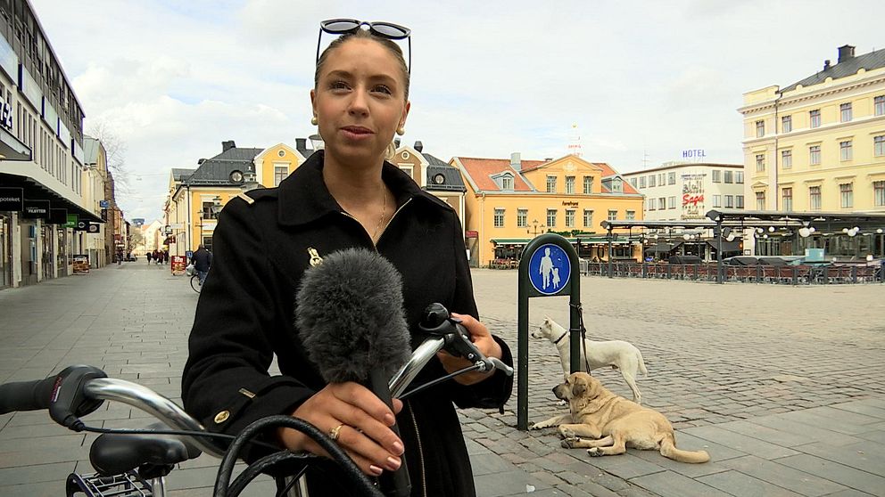 Felicia har solglasögon på huvudet och står vid ett torg i centrala Linköping.