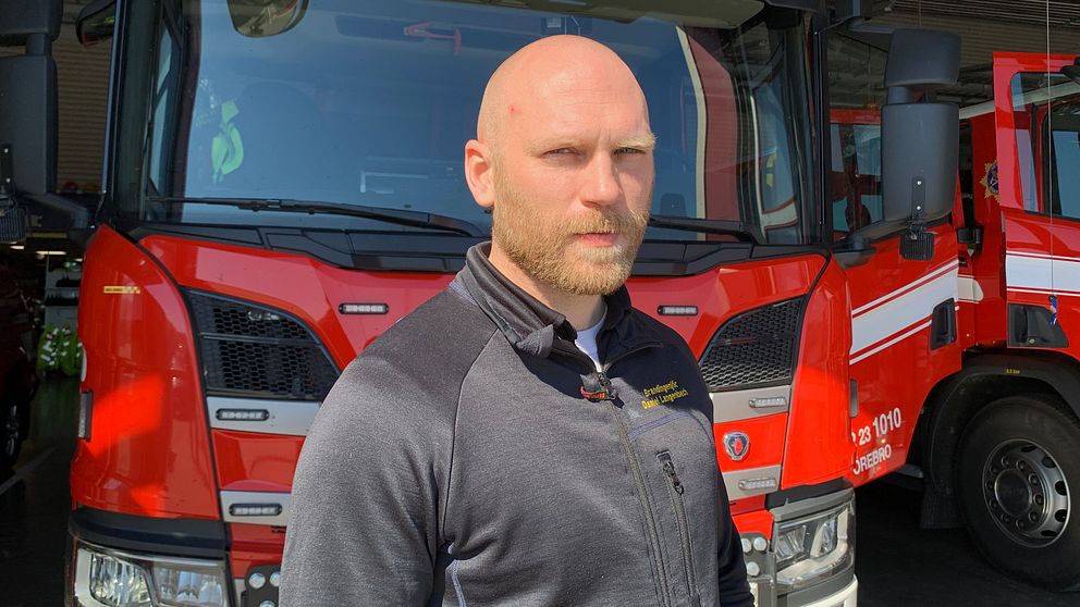 Daniel Langenback som var räddningsledare under insatsen i Zinkgruvan i Askersund står framför en brandbil.