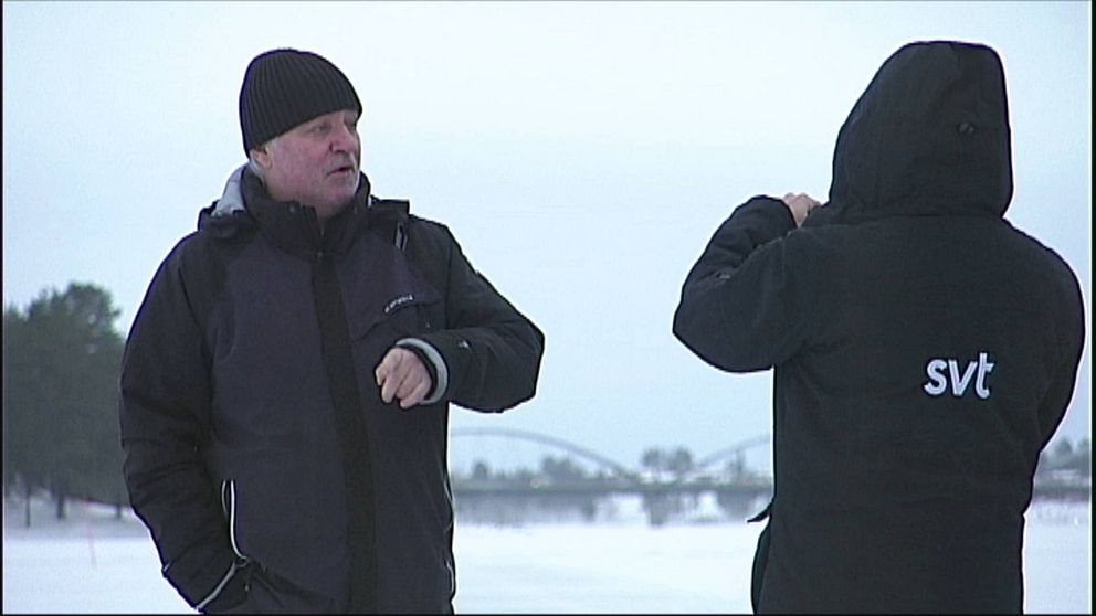 Jan Blomkvist blir fotograferad utomhus av reporter från SVT.