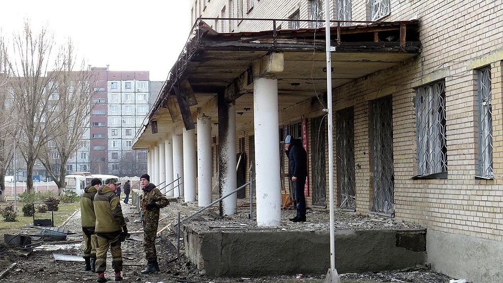 Proryska separatist-soldater framför det sjukhus i Donetsk som träffades av artillerield.