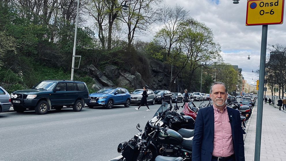 Daniel Helldén (MP) trafikborgarråd står framför en motorcykelparkering i Stockholm.