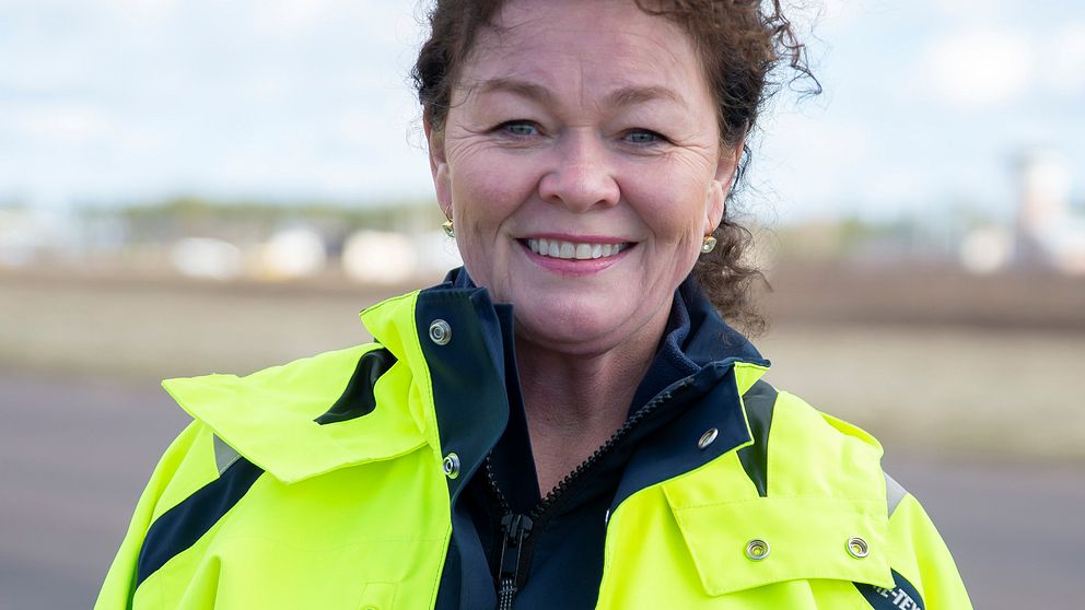 Camilla Sperling i en ljusgul jacka med Karlstad airports logotyp.