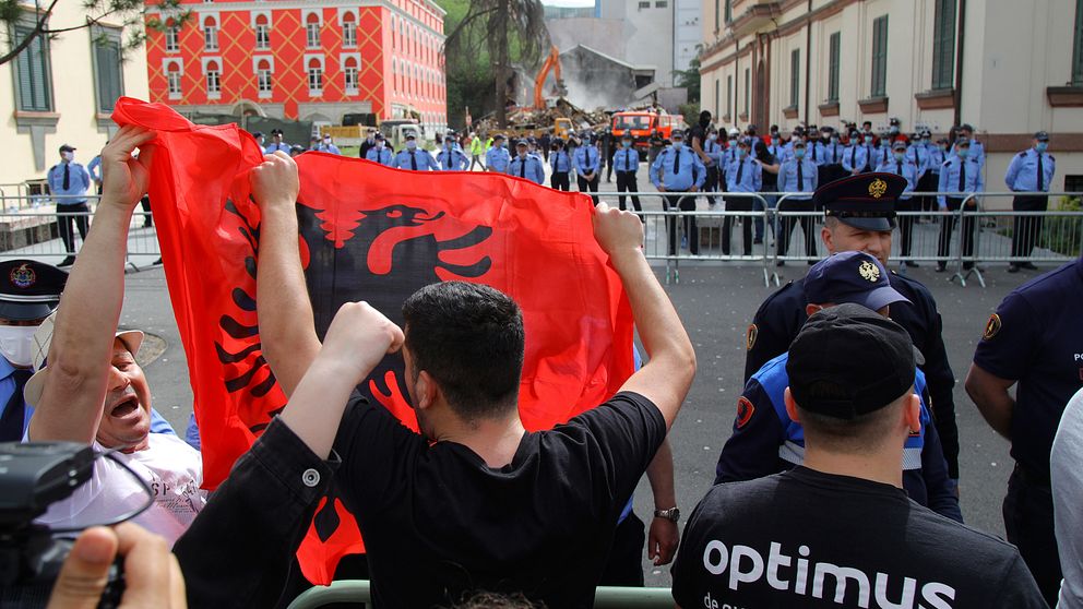 Demonstranter med den albanska flaggan protesterar mot rivningen av landets nationalteater på söndagen.
