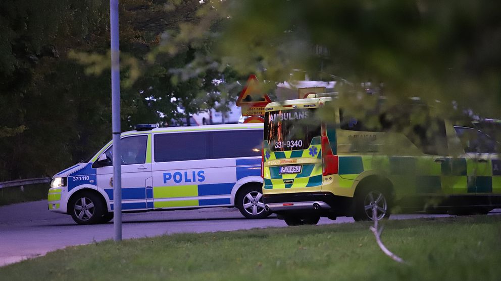 Polis och ambulans innanför avspärrningarna vid radhusområdet i Alby i Botkyrka kommun.