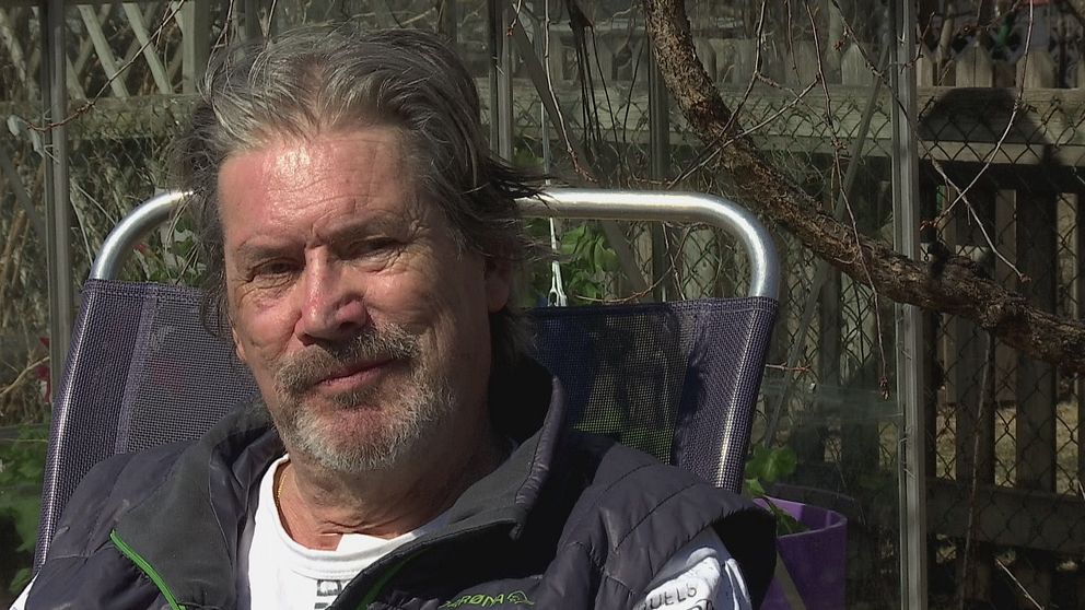 Rolf Andersson sitter på en stol utomhus med grenar i bakgrunden.