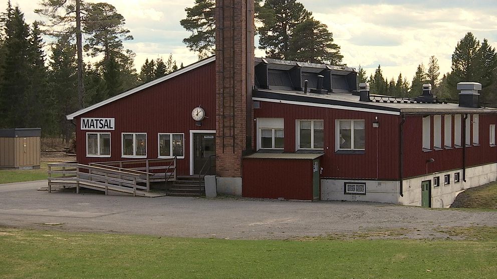 Bilr på rött hus med en skorsten i tegel och en skylt med texten ”Matsal”