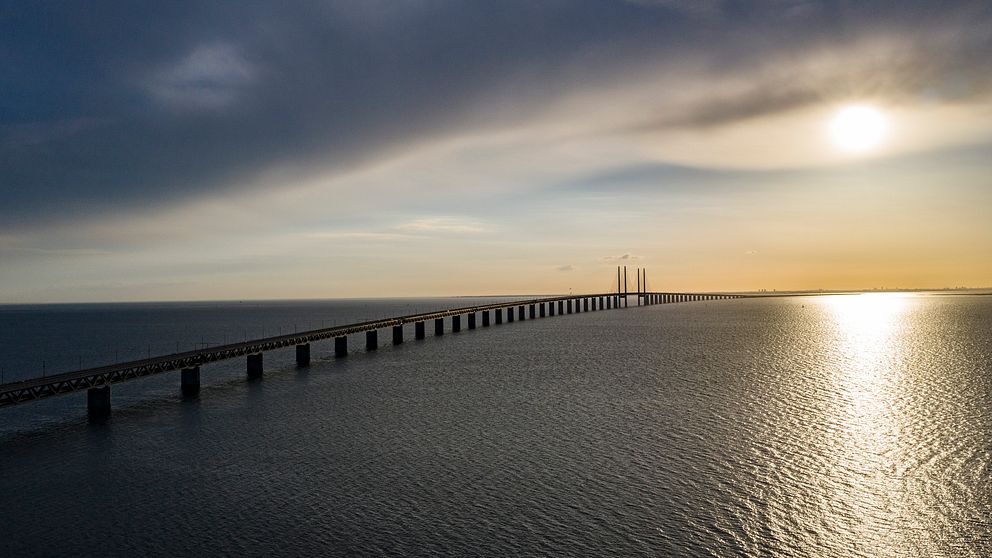 Svenskar som har fast bostad i Sverige får resa via Danmark vidare ut i världen på semester, enligt de danska reglerna. Öresundsbron i skymningen.