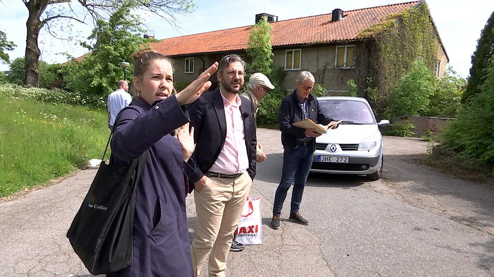 Arkitekten Elin Monie-Landerö pekar på byggnader. Kommunalrådet i Linköping Muharrem Demirok (C) tittar på. I bakgrunden står Reine Sundell, fastighetschef på Region Östergötland och bläddrar i mapp.