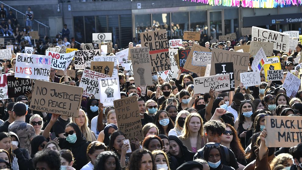 Deltagare med skyltar vid en tyst protest på Plattan, Sergels torg, i Stockholm City för att visa stöd för Black lives matter.