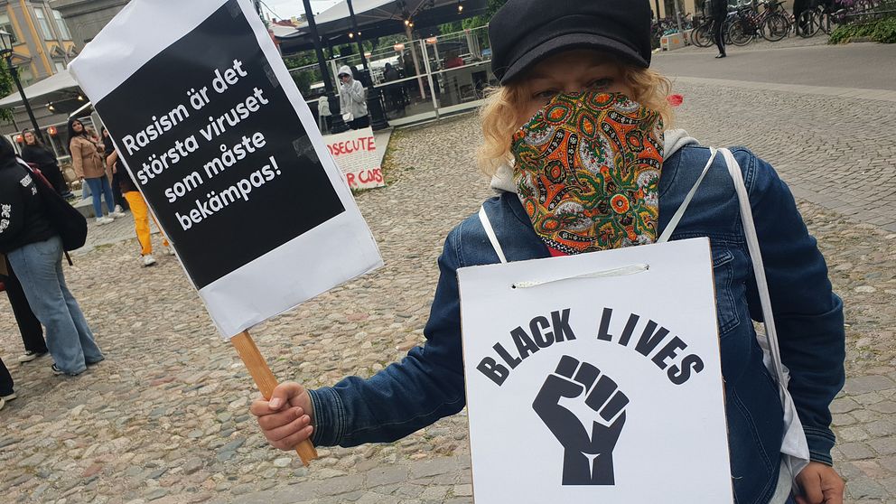 Demonstrant på Stortorget i Örebro med plakat och skylt på magen med texten ”Black life”
